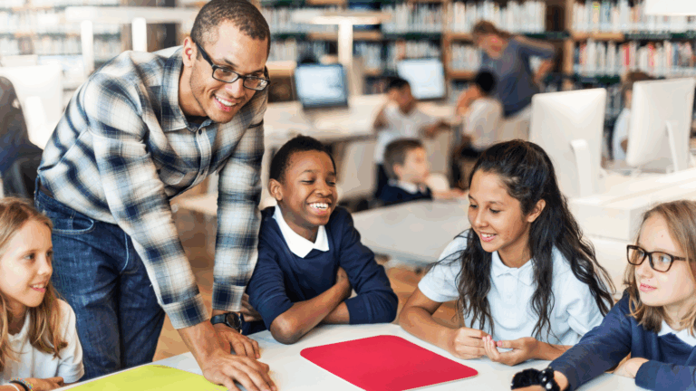 Adult with four students around a table